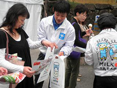 (MILK●JAPANグッズを活用して牛乳愛飲を呼びかける酪農家・住田佑樹さん・中央)